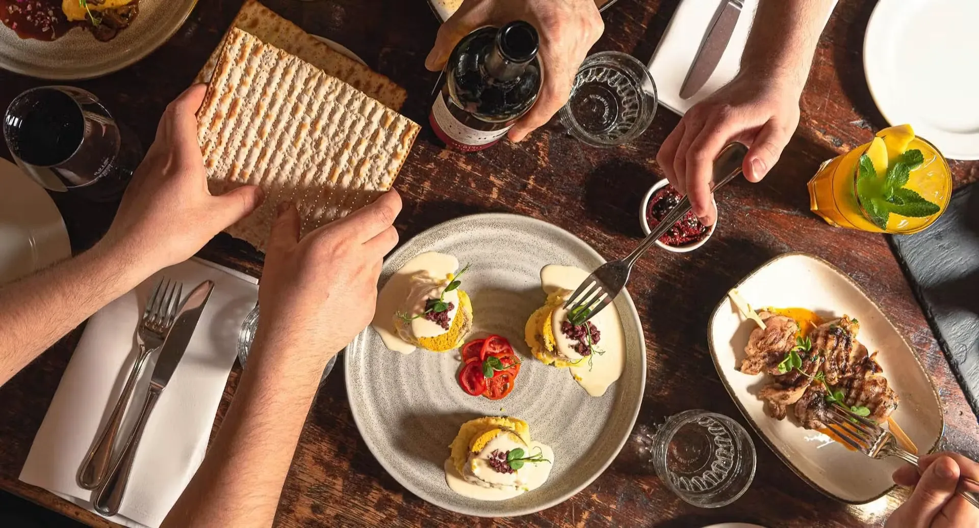 Guests at the laid table, breaking matzo