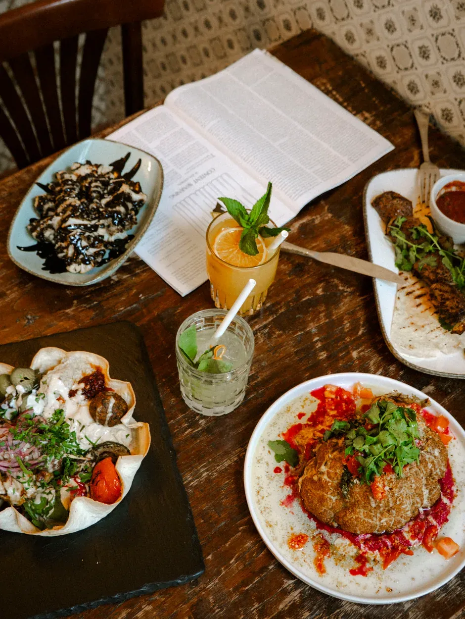 Laid table from above: mezze in a flatbread bowl, drinks and the menu