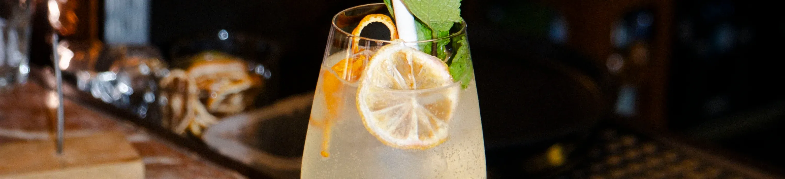 Cocktail with a lemon slice and mint on the bar counter