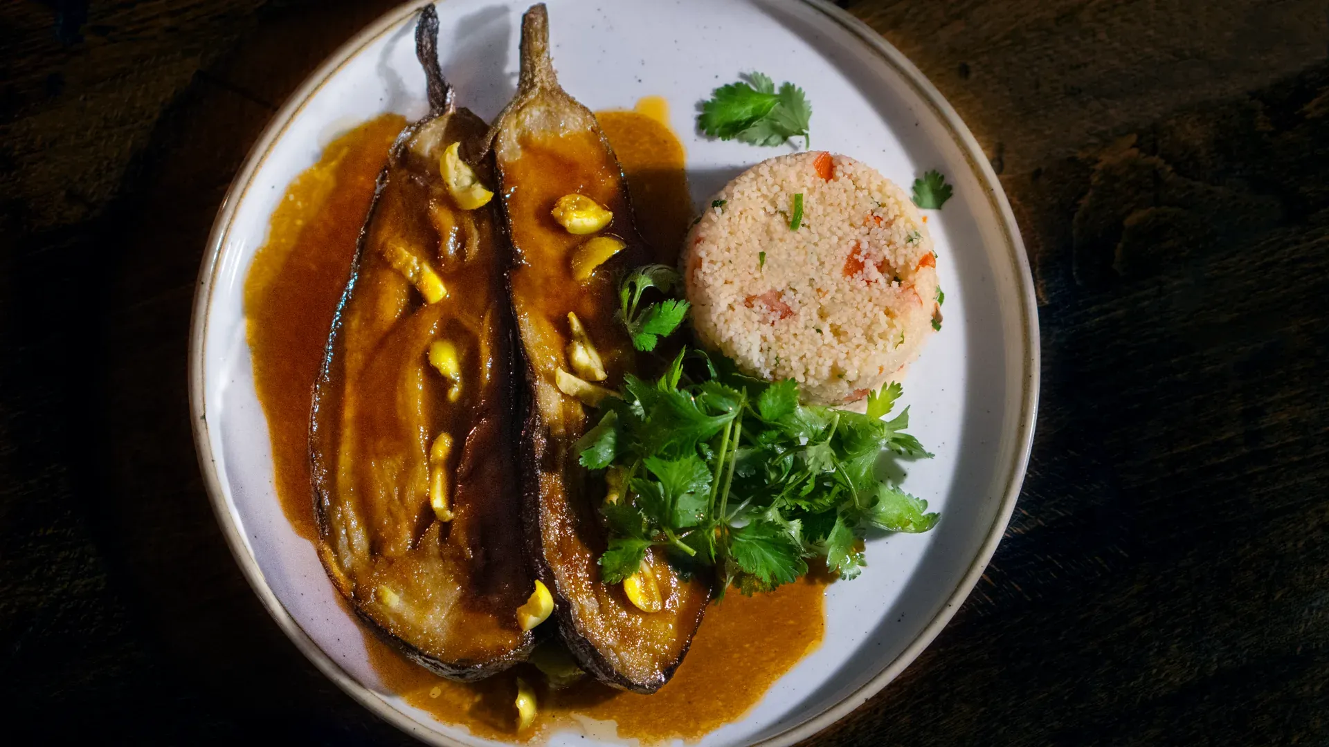 Braised aubergines in sauce with couscous and coriander