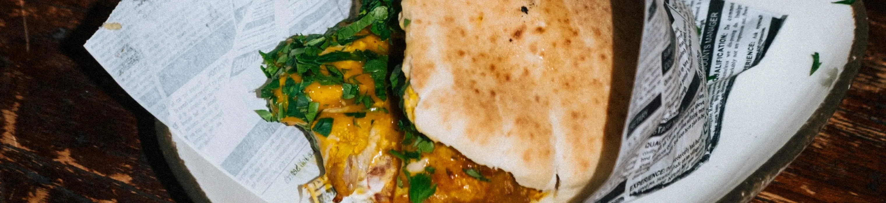 Pita with chicken and harissa, wrapped in paper
