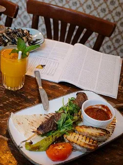 Gedeckter Tisch mit Saft, Zeitschrift und Grillspieß